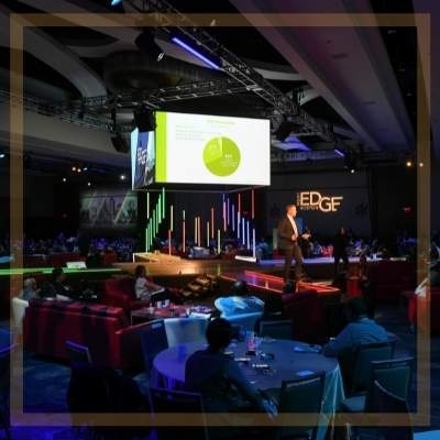 a stage with a large projection screen floating above it